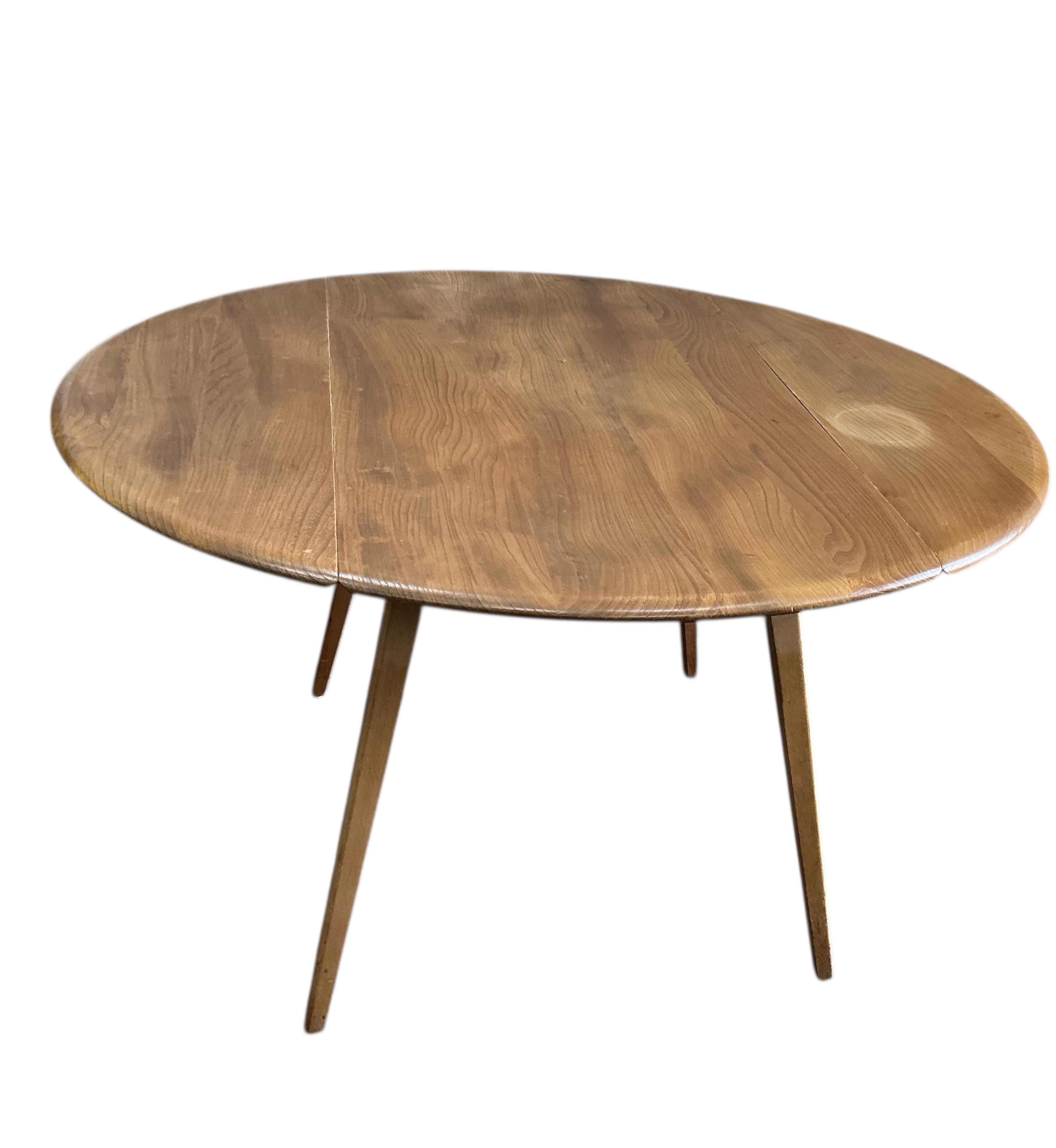 An Ercol elm and beech drop leaf dining table, width 112cm, depth 62cm, height 72cm and four Ercol elm and beech comb back dining chairs